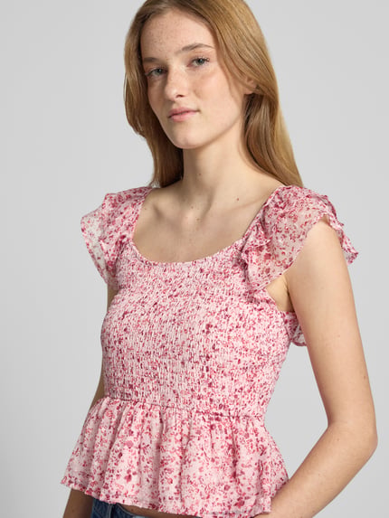 Frauenmodel trägt Slim Fit Blusentop mit Allover-Muster Modell 'ELIZA' von Only, floral, Chiffon, Volants, Henley-Ausschnitt, Nahaufnahme Oberkörper.