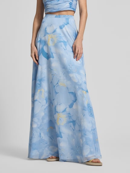 Frauenmodel trägt Regular Fit Maxirock mit floralem Allover-Print von Jake*s Cocktail in Hellblau mit Reißverschluss aus Chiffon, Nahaufnahme Oberkörper.
