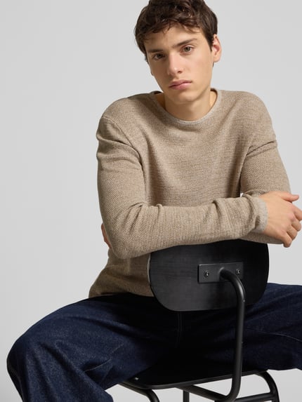 Männermodel draagt Strickpullover mit geripptem Rundhalsausschnitt Modell 'GEORGE' van Jack & Jones, beige, losvallend, katoenmix, Nahaufnahme bovenlichaam.