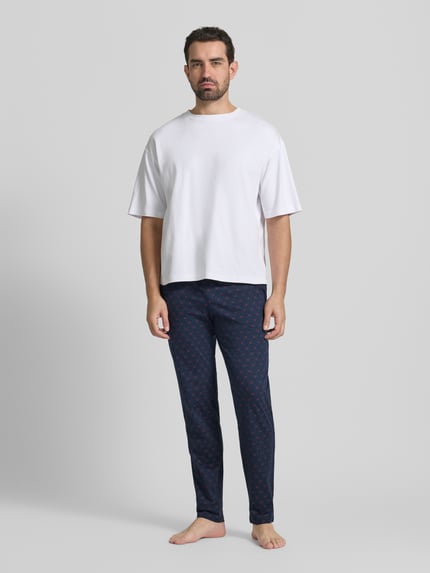 Männermodel trägt Sweatpants mit elastischem Bund von Schiesser in Dunkelblau mit Muster, Reine Baumwolle, Lockerer-Schnitt, Ganzkörperansicht von vorne.