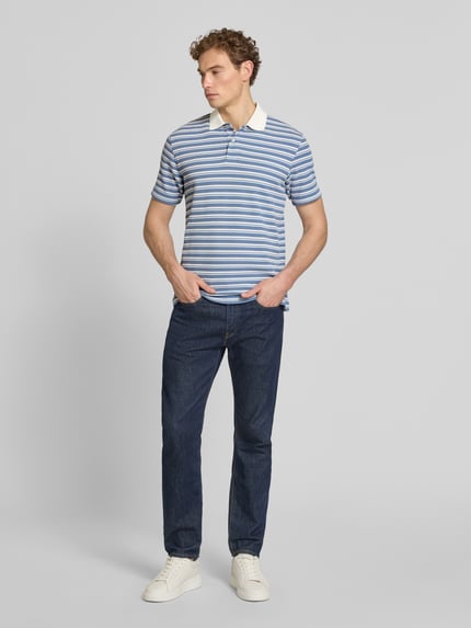 Męski model nosi Regular Fit Poloshirt aus Baumwoll-Mix Modell 'BLAZE' von SELECTED HOMME, efekt: jednolity kolor, krój regular fit, kołnierzyk polo, dekolt w serek, listwa guzikowa, krótki rękaw, wykończenie materiału: pika, materiał: mieszanka bawełny, Ganzkörperansicht von vorne.