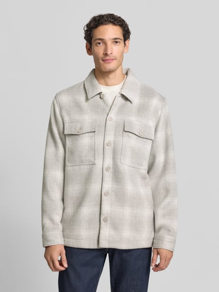Männermodel trägt Hemdjacke mit Brusttaschen Modell 'Losky_M' von BOSS Orange, kariertes Muster, Webware, Knöpfe, Ganzkörperansicht von vorne.