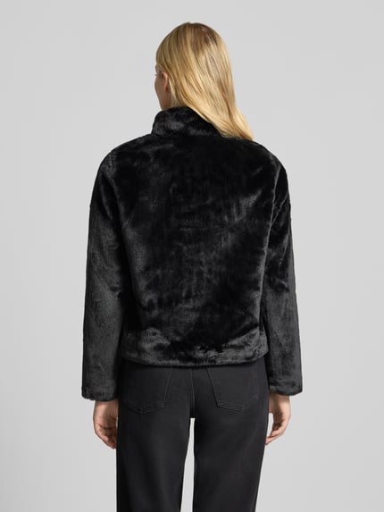 Frauenmodel trägt schwarze Regular Fit Webpelzjacke mit Stehkragen Modell 'NEWVIDA' von ONLY, weiche Textur, Ganzkörperansicht Rückansicht. Damen Teddy- / Webpelzjacke von ONLY.