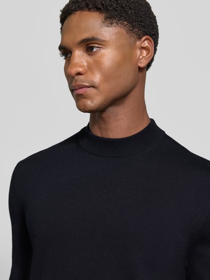 Männermodel trägt Regular Fit Pullover aus reiner Schurwolle Modell 'Davide' von JOOP! COLLECTION in Schwarz, Nahaufnahme Oberkörper