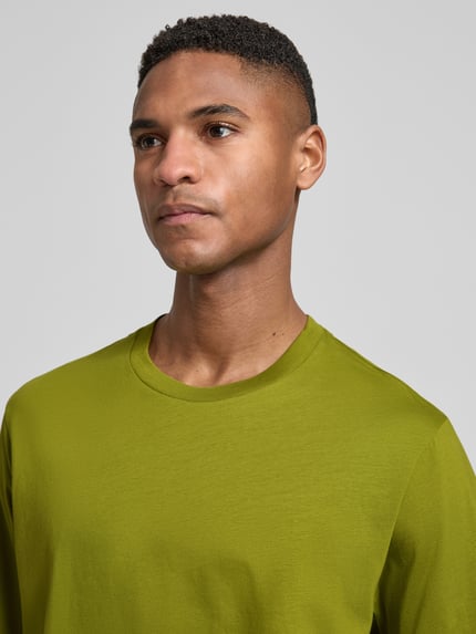 Männermodel trägt Relaxed Fit T-Shirt mit Rundhalsausschnitt von Schiesser in Grün, Reine Baumwolle, Kurzärmelig, Nahaufnahme Oberkörper, Rückenlänge bei Größe 50: 69 cm.