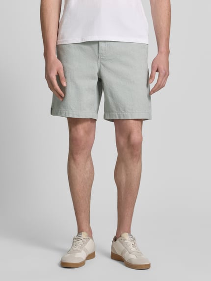 Männermodel trägt Regular Fit Shorts aus Baumwoll-Mix Modell 'SANDREW' von BOSS Orange, jednokolorowy, szlufki na pasek, naszywka z logo, krój regular fit, zapięcie na guzik i ukryty zamek błyskawiczny, tylna kieszeń, wpuszczane kieszenie boczne, wykończenie: splot twill żakardowy, materiał: mieszanka bawełny; Ganzkörperansicht von vorne.