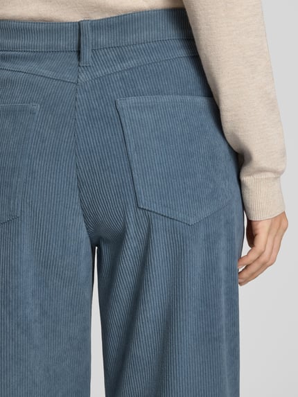 Frauenmodel trägt Regular Fit Cordhose mit weitem Bein von S. OLIVER BLACK LABEL in Uni-Optik, Struktur, Cordmaterial, Detailaufnahme Rückansicht.