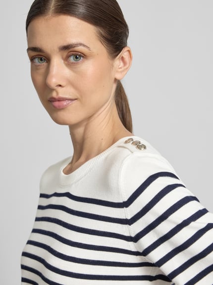 Frauenmodel trägt Strickshirt aus Viskose-Elasthan-Mix mit Knopfleiste von Milano Italy, Streifenmuster, Nahaufnahme Oberkörper.