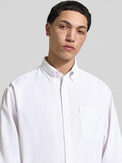 Männermodel trägt Regular Fit Freizeithemd mit Brusttasche Modell 'NORREBRO' von Jack & Jones, weiß mit feinen Streifen, Nahaufnahme Oberkörper, Baumwoll-Mix, Button-Down-Kragen, Knopfleiste