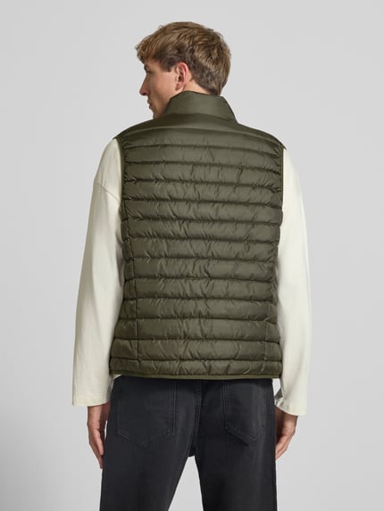 Męski model nosi kamizelkę pikowaną z zamkiem błyskawicznym Model 'ELVIS' od JACK & JONES, krój regular fit, stójka, detal z logo, zielony kolor, zdjęcie całej sylwetki od tyłu, Długość tyłu w rozmiarze M: 67 cm, Szerokość ramion w rozmiarze M: 41 cm, Szerokość klatki piersiowej w rozmiarze M: 54 cm