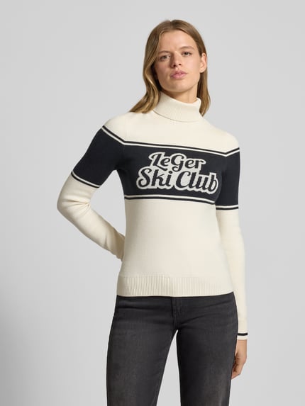 Vrouwenmodel draagt Strickpullover mit gerippten Abschlüssen Modell 'Elna' van LeGer by Lena Gercke, wit en zwart, regular fit, label-print, viscosemix, rolkraag, close-up bovenlichaam.
