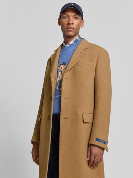 Männermodel trägt Regular Fit Mantel aus Woll-Mix von Polo Ralph Lauren in Camel, glatte Textur, Nahaufnahme Oberkörper. Herren Mantel von Polo Ralph Lauren