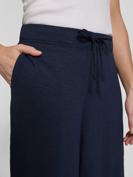 Frauenmodel trägt Culotte mit Kordelzug und Eingrifftaschen von Französische, dunkelblau, Gerader-Schnitt, Elastikbund, Nahaufnahme Oberkörper.