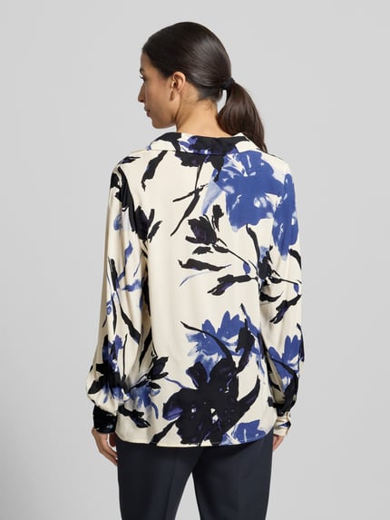 Vrouwenmodel draagt Blusenshirt met V-hals model 'BENE' van Soyaconcept in crèmekleur met blauwe en zwarte bloemenprint, pure viscose, losse snit, ruglengte 66 cm, mouwlengte 63 cm, rugaanzicht.