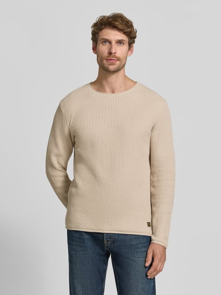 Männermodel trägt Strickpullover mit Struktur-Muster Modell 'BLUMASON' von JACK & JONES in Beige und Jeans, Ganzkörperansicht von vorne, reine Baumwolle, gerader Schnitt.