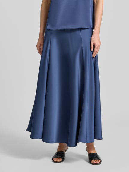 Vrouwenmodel draagt Maxirock aus Satin mit elastischem Bund van Zero, A-lijn, deelnaden, elastische tailleband, satijnstructuur, kleur blauw, detailopname onderlichaam.