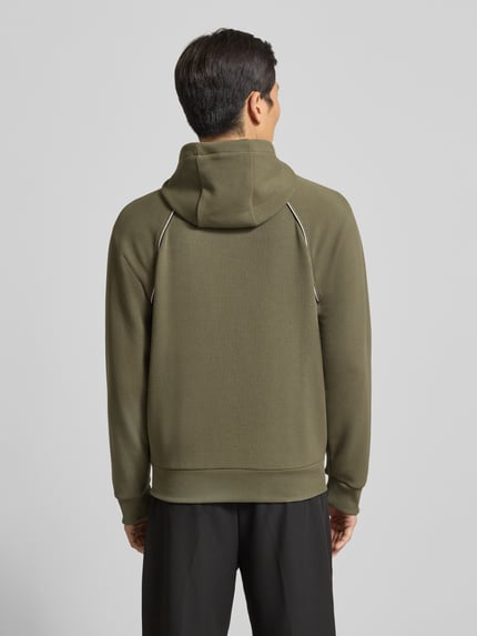 Männermodel trägt Regular Fit Sweatjacke aus Baumwoll-Mix von BOSS Green in Khaki mit Kapuze, Kontraststreifen, Piqué-Struktur, Ganzkörperansicht Rückansicht.