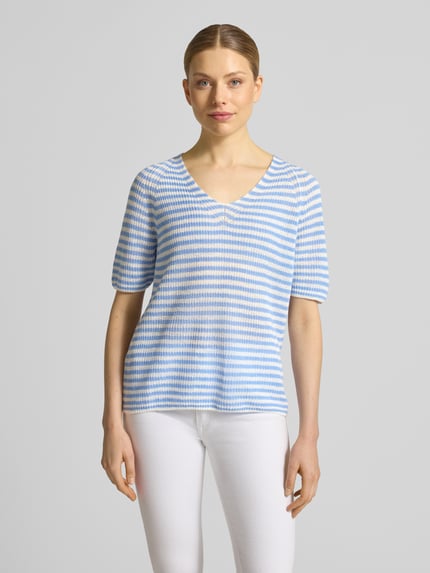 Vrouwenmodel draagt T-shirt uit linnen met V-hals van Fynch-Hatton, regular fit, all-over look, maat S ruglengte 59 cm, mouwlengte 23 cm, lichtblauwe en witte strepen, textuur met lichte structuur, vooraanzicht van het hele lichaam.
