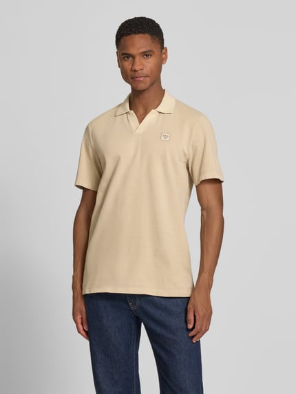 Männermodel trägt Regular Fit poloshirt aus puur katoen van s.Oliver RED LABEL, look: effen, labelpatch, piqué structuur, korte mouw, rompzoom met zijsplitten, polokraag, v-hals, vooraanzicht bovenlichaam.