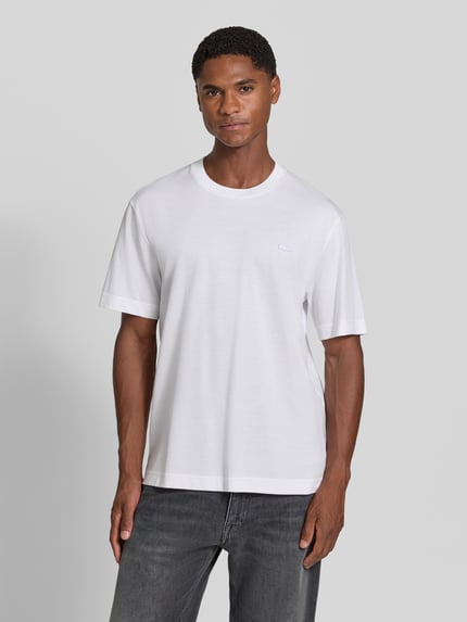 Männermodel trägt Regular Fit T-Shirt aus reiner Baumwolle von Lacoste in Weiß mit glatter Textur, Ganzkörperansicht von vorne. Herren T-Shirt von Lacoste