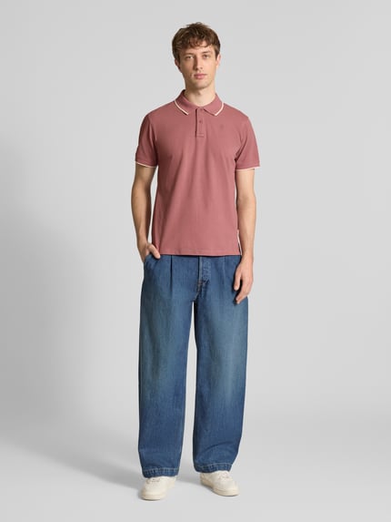 Männermodel trägt Regular Fit Poloshirt mit Logo-Stitching Modell 'Hedin' von Blend in Rosa, kurzärmelig, Baumwolle, Ganzkörperansicht von vorne.