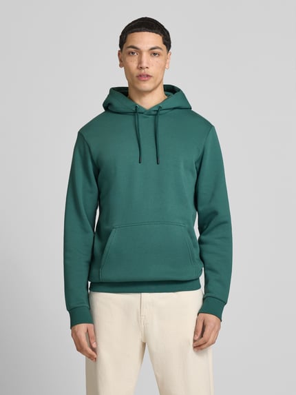Männermodel trägt Regular Fit Hoodie aus Baumwoll-Mix Modell 'CERES' von Only & Sons, Optik: Unifarben, Kängurutasche, Ganzkörperansicht von vorne.