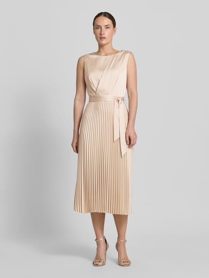 Frauenmodel trägt Midikleid mit Plisseefalten und Bindegürtel von Comma, A-Linie, Material-Mix mit Stretch-Anteil, Ganzkörperansicht von vorne.