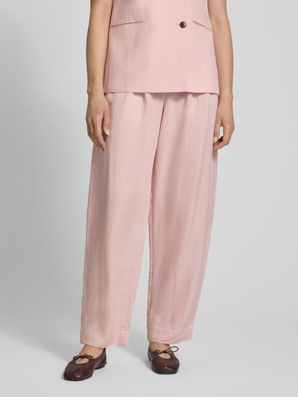 Frauenmodel trägt High Waist Stoffhose aus Viskose-Mix Modell 'Franciska' von MSCH Copenhagen in zartem Rosa, Barrel Fit, Leinen-Viskose-Anteil, feine Textur, Gesäßtaschen, Bundweite 36 cm, Innenbeinlänge 79 cm, Ganzkörperansicht von vorne.