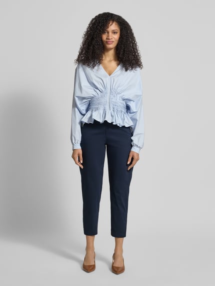 Frauenmodel trägt Straight Fit Stoffhose mit Eingrifftaschen Modell 'Ornela' von STEHMANN aus elastischem Baumwoll-Mix, verkürzte Passform, dunkelblau, Ganzkörperansicht von vorne.