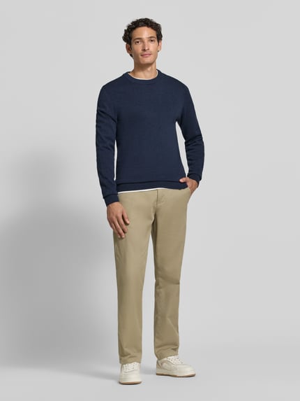 Männermodel trägt Strickpullover aus Baumwoll-Kaschmir-Mix mit Rundhalsausschnitt von MCNEAL, Regular Fit, beige Hose, Ganzkörperansicht von vorne.