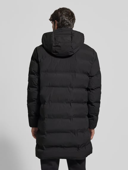 Männermodel trägt Steppmantel mit verdecktem Reißverschluss und Eingrifftaschen von MCNEAL in Schwarz, Rückenansicht, Ganzkörperansicht Rückansicht. Rückenlänge 100 cm, Schulterbreite 48 cm, Brustweite 59 cm, Ärmellänge 64 cm, Regular Fit, Kapuze, glatte Textur.