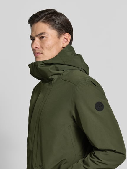 Männermodel trägt Regular Fit Jacke mit Kapuze Modell 'Adam' von Didriksons in Olivgrün, glatte Textur, Nahaufnahme Oberkörper. Rückenlänge, Schulterbreite, Brustweite und Ärmellänge bei Größe M laut Kontext.