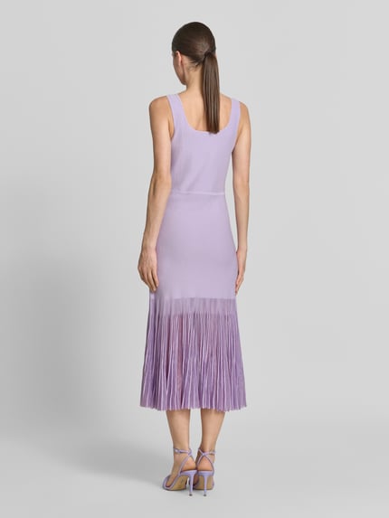 Vrouwenmodel draagt Strickkleid aus Rippstrick van BOSS in lichtpaars met transparante plisséplooien, knielang, nauwsluitende pasvorm, rugaanzicht hele lichaam.