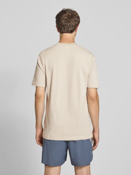Männermodel trägt Regular Fit T-Shirt aus reiner Baumwolle Modell 'M SL SJ T' von adidas Sportswear in Beige, Ganzkörperansicht Rückansicht.