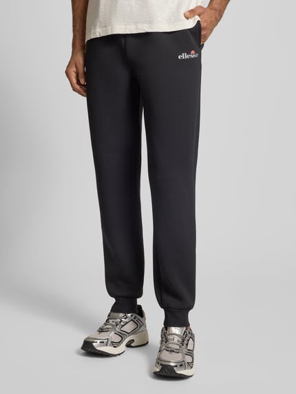 Mannenmodel draagt zwarte Sweatpants met Logo Modell 'SIRTORI' van Ellesse, regular fit, elastische taille, zijaanzicht, detailopname.
