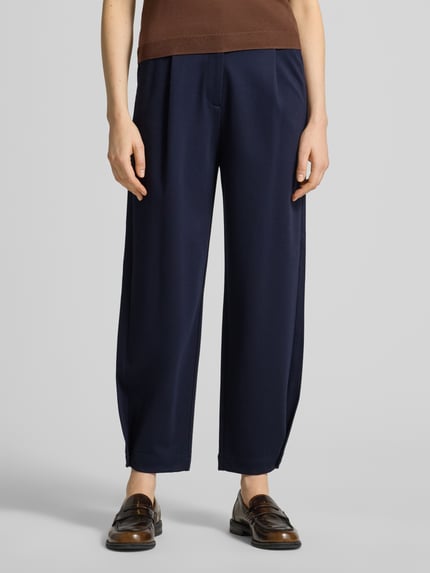 Frauenmodel trägt Barrel Fit Sweathose aus Viskose-Mix von s.Oliver RED LABEL, Optik: Unifarben, Passform: Barrel Fit, Mid Waist, Label-Applikation, Knopf und verdeckter Reißverschluss, Bundabschluss: Elastisch, seitliche Eingrifftaschen, angedeutete Paspeltaschen, Material: Viskose-Mix, Ganzkörperansicht von vorne.
