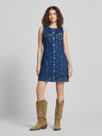Frauenmodel trägt Regular Fit Minikleid in Denim-Optik mit Logo-Patch von Calvin Klein Jeans aus Reine Baumwolle, Ganzkörperansicht von vorne.
