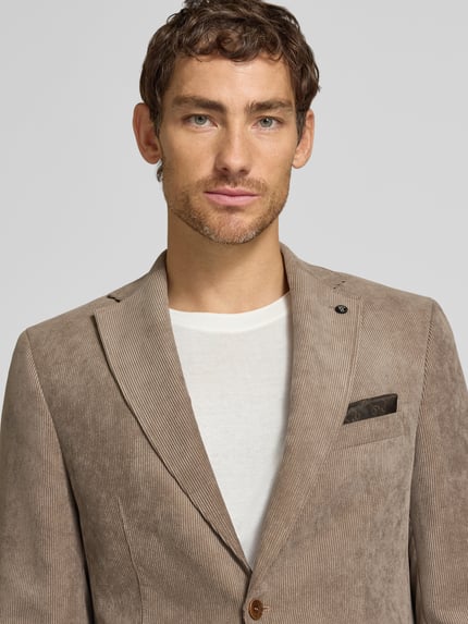 Männermodel trägt Sakko mit Pattentaschen und Reverskragen Modell 'Theo' von Carl Gross, Cord, Regular Fit, Nahaufnahme Oberkörper