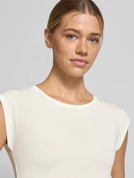 Vrouwenmodel draagt Slim Fit T-Shirt uit lyocell-mix model 'AVASARAH' van Vero Moda, effen, met zijplooien, ronde hals, korte mouw, close-up bovenlichaam.