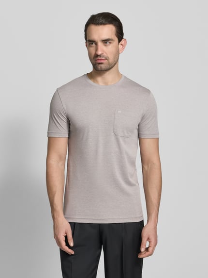 Männermodel trägt T-Shirt mit Rundhalsausschnitt und Brusttasche von Christian Berg Men, Baumwoll-Anteil, Regular-Fit, hellgrau, Ganzkörperansicht von vorne. Rückenlänge bei Größe M: 72 cm.
