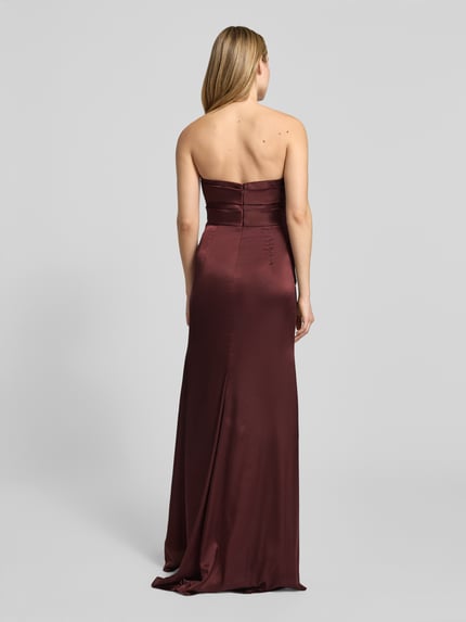 Vrouwenmodel draagt avondkleid uit satijn in off-shoulder-look met split van Luxuar, A-lijn, maxi, achterkant, detailopname.