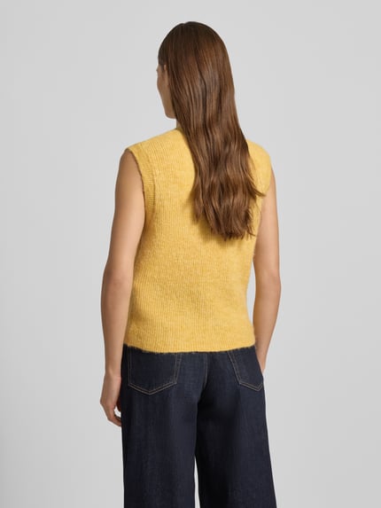 Frauenmodel trägt Regular Fit Strickjacke aus Woll-Mix von Selected Femme in Uni-Gelb, ärmellos, Strukturstrick, Ganzkörperansicht Rückansicht.