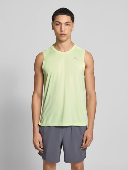 Męski model nosi Top mit Logo und Rundhalsausschnitt von PUMA PERFORMANCE, krój regular fit, logo, okrągły dekolt, długość tyłu w rozmiarze M: 71 cm, jasna zieleń, gładka tekstura, przód, całe ciało