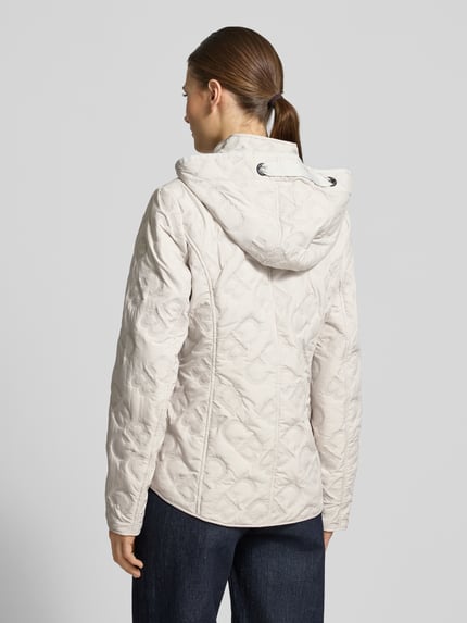 Frauenmodel trägt Jacke mit Stehkragen und Reißverschlusstaschen von Gil Bret in Beige, tailliert, mit Kapuze und Weatherprotection, Ganzkörperansicht Rückansicht.