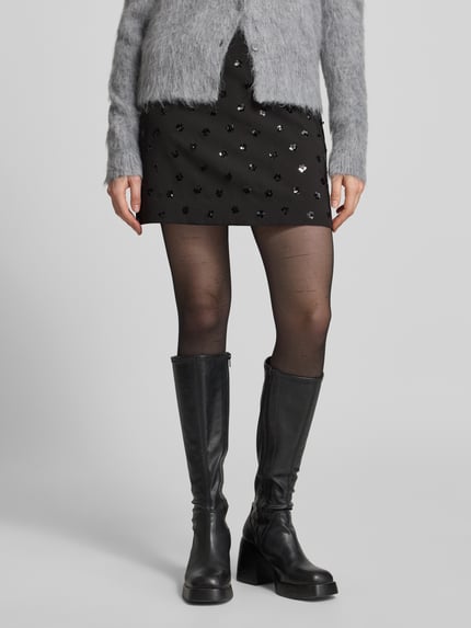 Frauenmodel trägt Minirock mit Pailletten Modell 'HARMONIA' von ICHI, schwarz, gerader Schnitt, Material-Mix, Nahaufnahme Unterkörper.