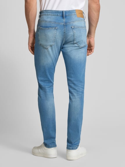 Mężczyzna nosi Slim Fit Jeans aus Baumwoll-Mix Modell 'LOOM' von Only & Sons, jasnoniebieski denim, label patch, krój slim fit, 5 kieszeni, widok całej sylwetki z tyłu.