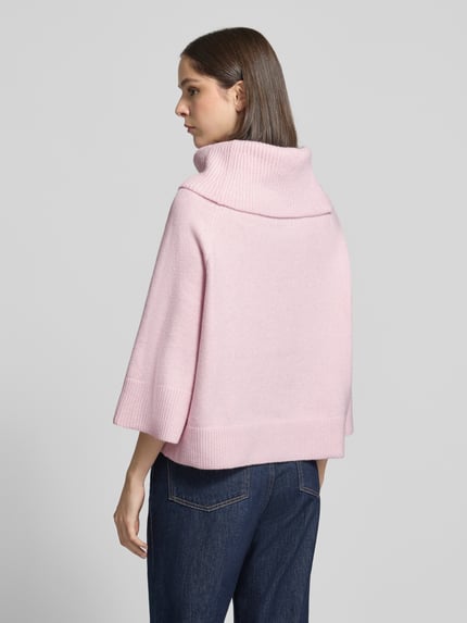 Frauenmodel trägt Oversized Strickpullover mit Woll-Anteil von COMMA in zartem Rosa, elastischer Material-Mix, gerippter Umlegekragen, Raglanärmel, gerippte Abschlüsse, Rückenansicht, Ganzkörperansicht Rückansicht.
