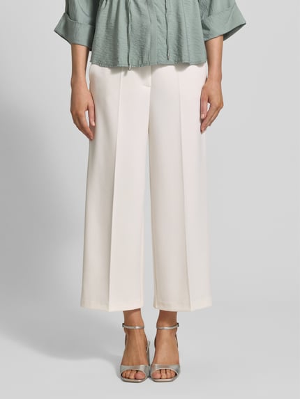 Frauenmodel trägt Wide Fit Stoffhose mit Bügelfalten Modell 'Juli' von Betty Barclay in Creme, glatte Textur, Nahaufnahme Oberkörper, Damen Stoffhose aus elastischem Material-Mix mit Haken- und Reißverschluss.