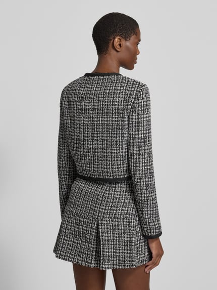 Kobiece model prezentuje żakiet Slim Fit Bouclé-Optik Model 'JOLE' od GUESS, czarno-biała imitacja bouclé, Mieszanka materiałów z dodatkiem wiskozy, listwa guzikowa na całej długości, kieszenie na piersi, Długość tyłu w rozmiarze S: 44 cm, Szerokość w rozmiarze S: 45 cm, Długość rękawów w rozmiarze S: 62 cm, widok całej sylwetki od tyłu.