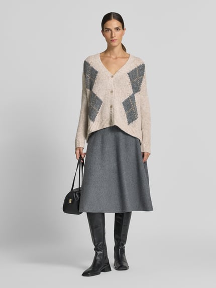 Vrouwenmodel draagt gebreid jack met v-hals van Luisa Cerano, materiaalmix met alpaca, relaxed fit, all-over look, knoopsluiting, ruglengte maat 36: 61 cm, mouwlengte maat 36: 46 cm, grijze en beige tinten, grove textuur, ganzekörperaanzicht van voren.